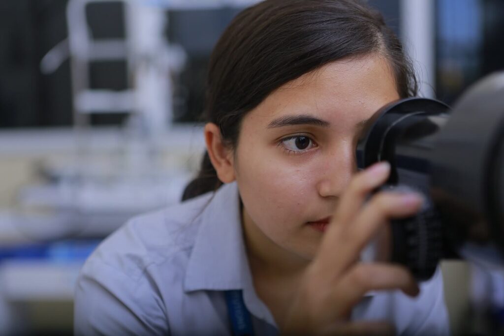 This picture represents a girl optometrist seeing into a keratometer